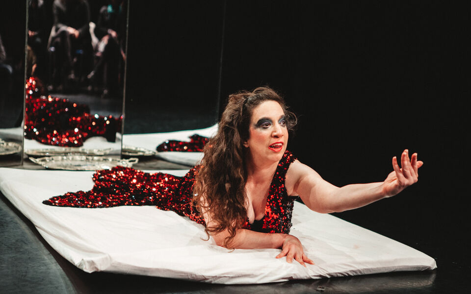 Female performer lying on the floor of a theatre stage