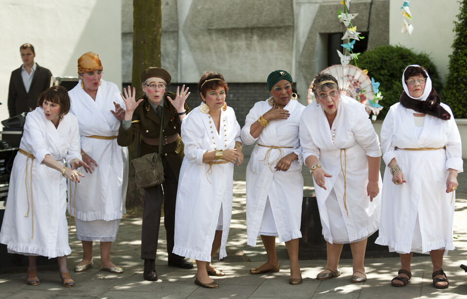 A photo of actors during a performance of "Trojan Women"