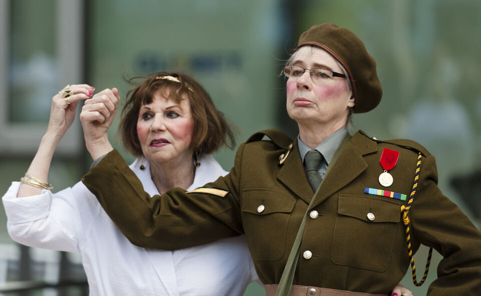 A photo of two actors during a performance of "Trojan Women"