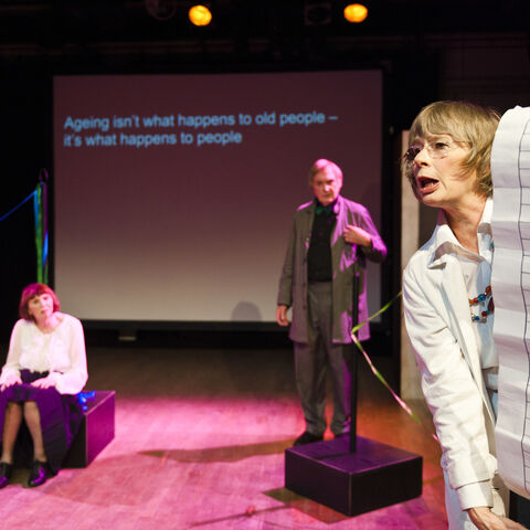 A photo of actors on stage during a performance of "Still Life Dreaming"